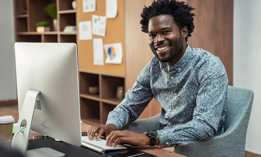 smiling man writing content for social media marketing