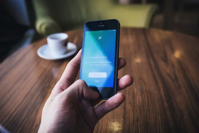 Person looking at Twitter on phone for Houston social media marketing