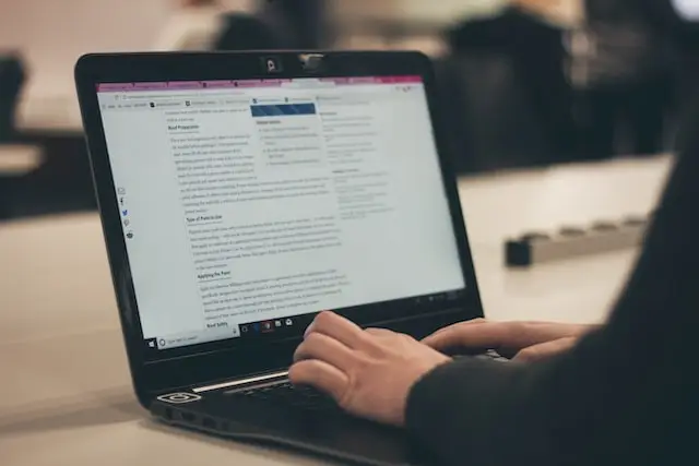 person writing content on laptop for Houston SEO