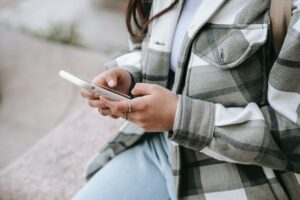 Girl typing question on phone for quick response from Houston social media marketing